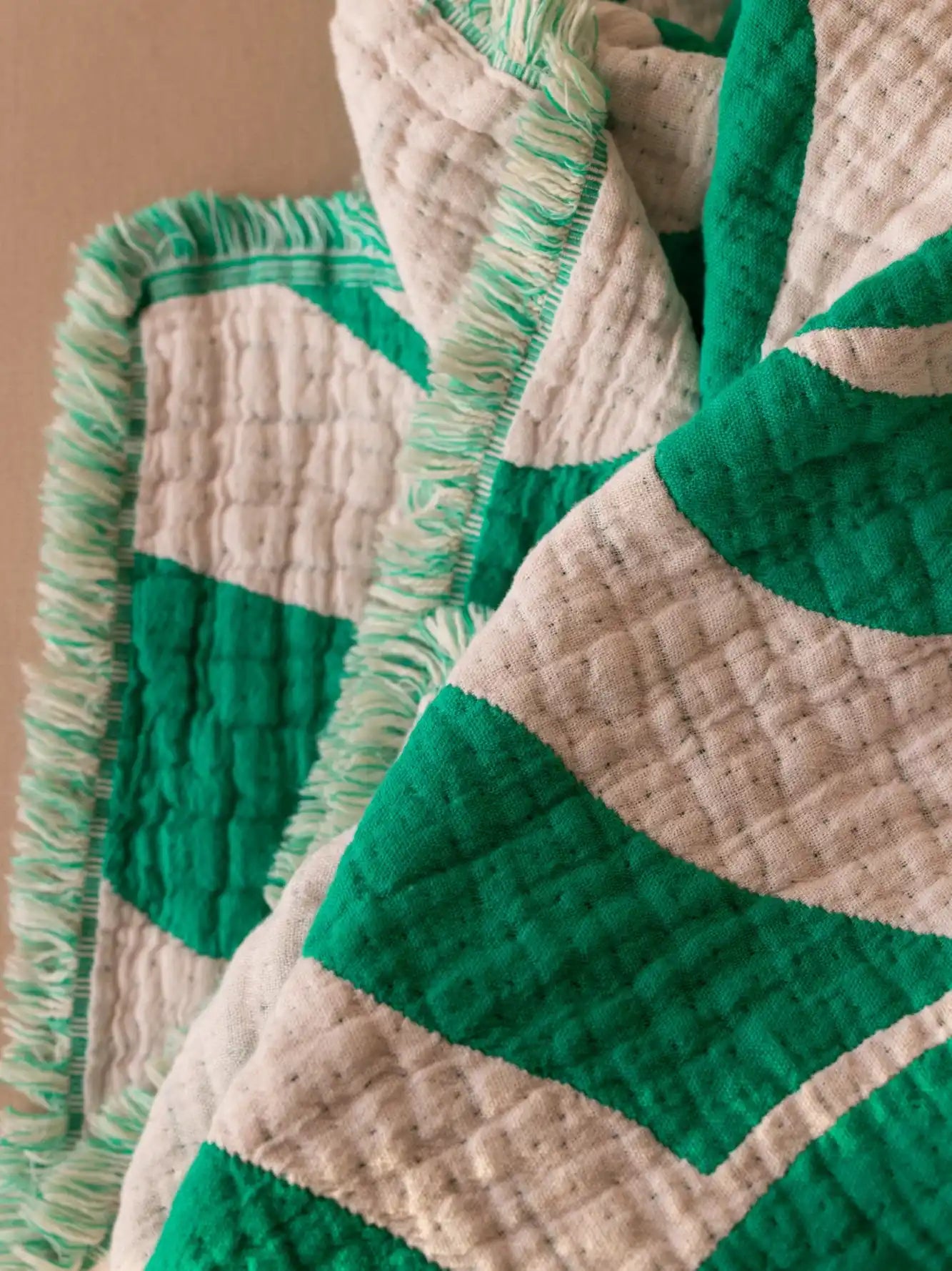 Grüne Kuscheldecke mit Detail auf Naturfasern Baumwolle