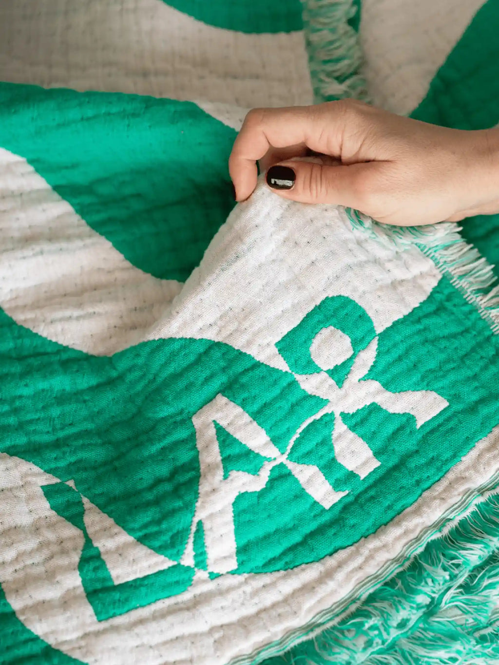 Logo von LAR Home bei grüner Kuscheldecke
